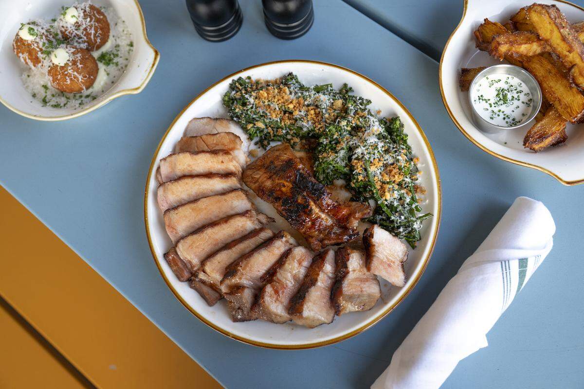 The double-cut pork chop, arancini balls, and pavé fries at Good Neighbor in Sacramento on Thursday, Jan. 29, 2026.