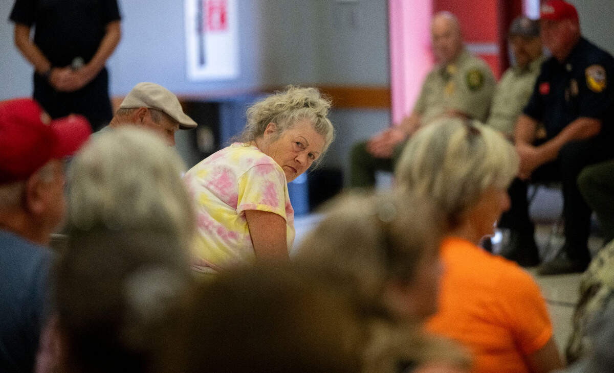 Cathy Sharp of Swansboro listens to a concerned citizen ask a question during a Crozier Fire town hall meeting at Sutter’s Mill School in Placerville on Sunday. Sharp and her husband Mickey evacuated with their five dogs and are waiting to return home.