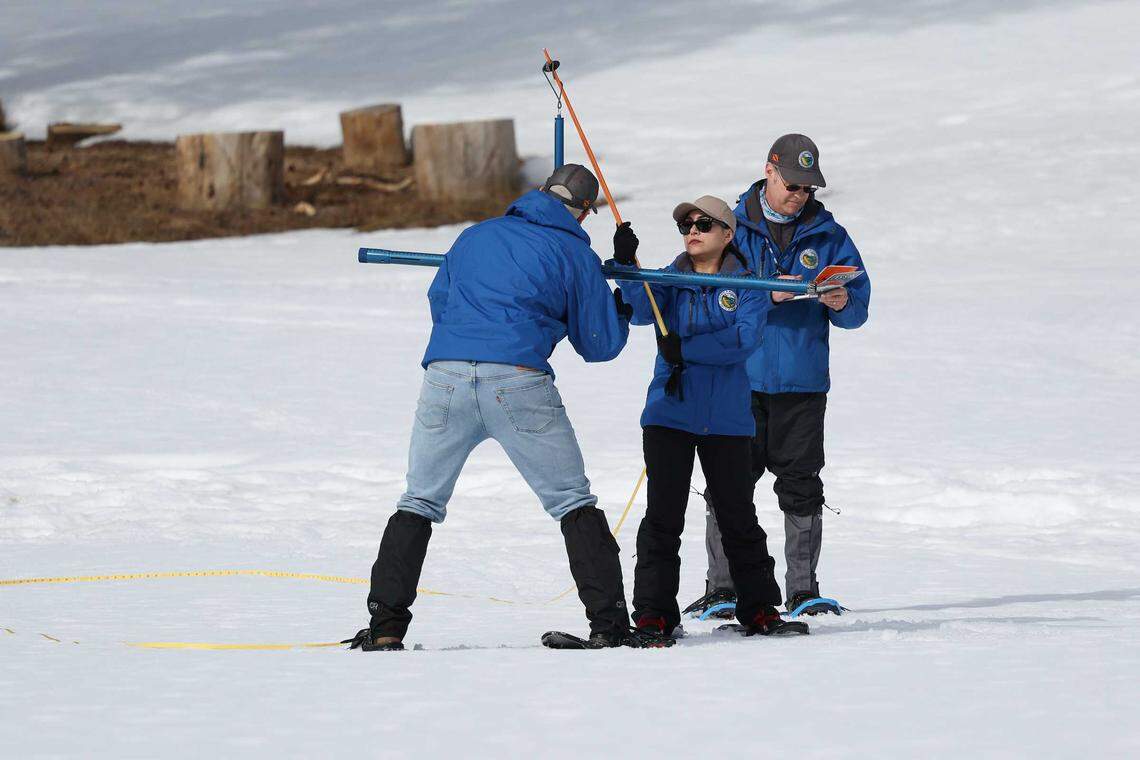 From left, state engineer Jacob Kollen, hydrometeorologist Angelique Fabbiani-Leon and snow survey manager Andy Reising conduct the second media snow survey of the 2026 season at Phillips Station on Friday.