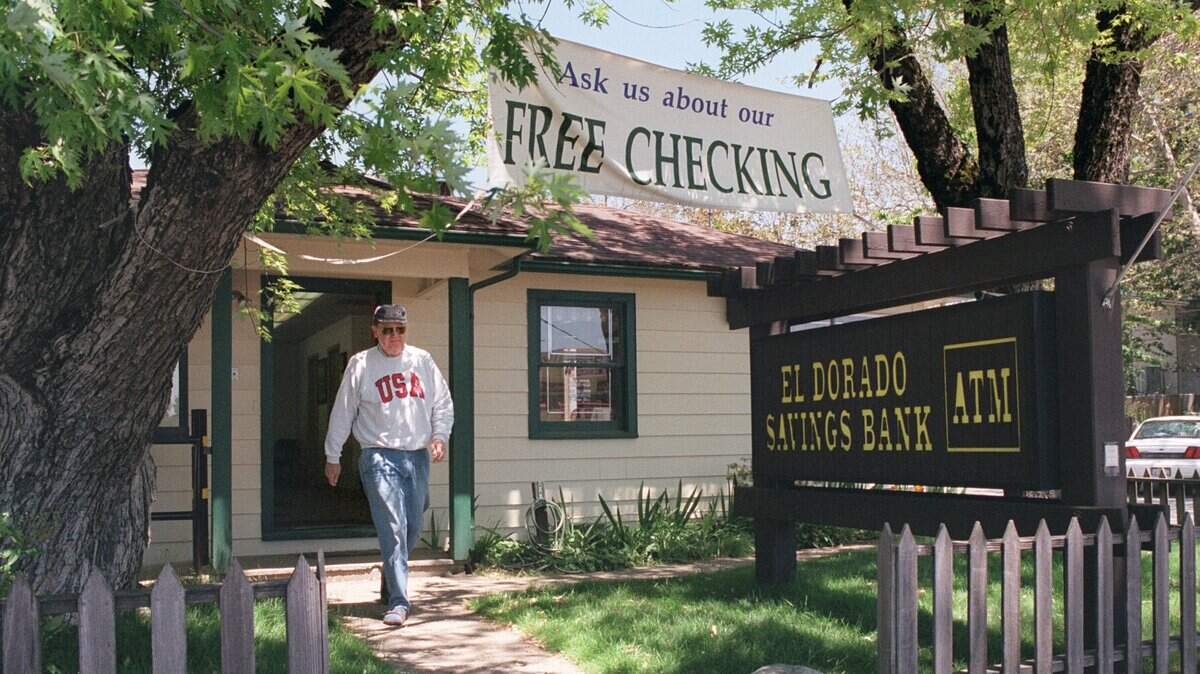 FILE -- A customer leaves the El Dorado Savings Bank in Georgetown, located inside a house at the time.