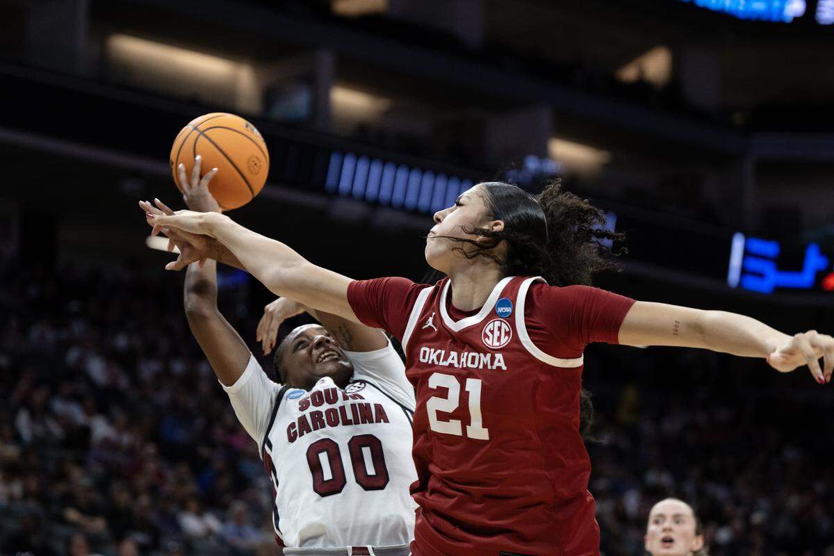 South Carolina Gamecocks guard Ta'niya Latson is fouled by Oklahoma Sooners forward Brooklyn Stewart as she shoots in the second half of an NCAA Women’s Basketball Tournament Sweet 16 game Saturday at Golden 1 Center in Sacramento.
