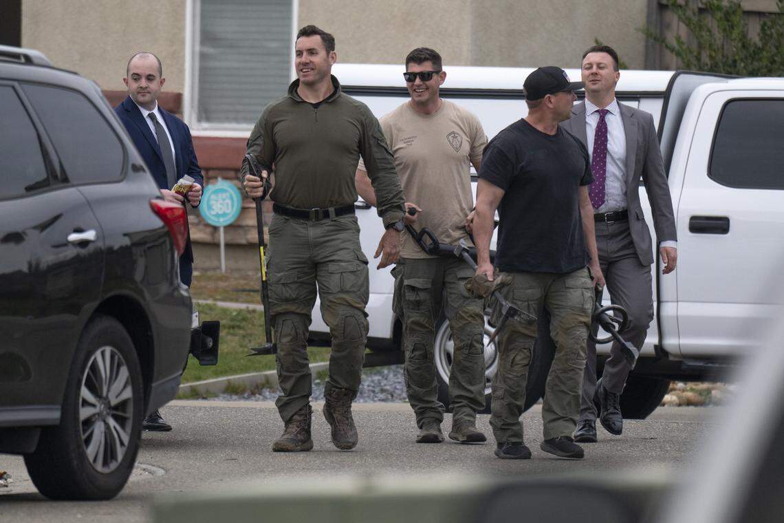 Law enforcement officers enter a crime scene with tools at a home on Mill Water Circle in Rancho Cordova where four people were found shot to death on Tuesday, Jan. 27, 2026.