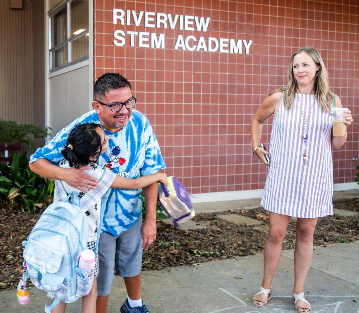 A student excitedly greets third grade teacher Troy Martinez, left, at Riverview STEM Academy on Thursday, Aug. 7, 2025.