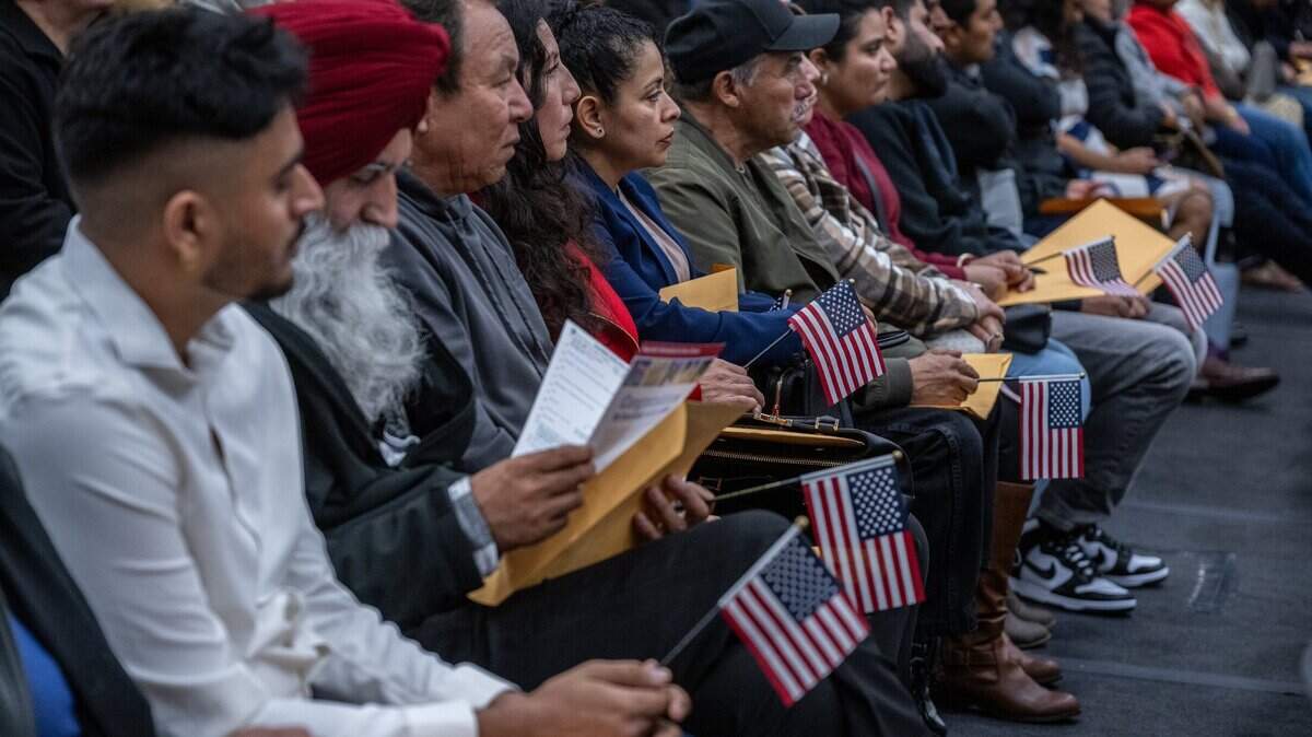 New U.S. citizens hold American flags during a U.S. Citizenship and Immigration Services naturalization ceremony At the Grounds in Roseville on Wednesday, Dec. 20, 2023.
