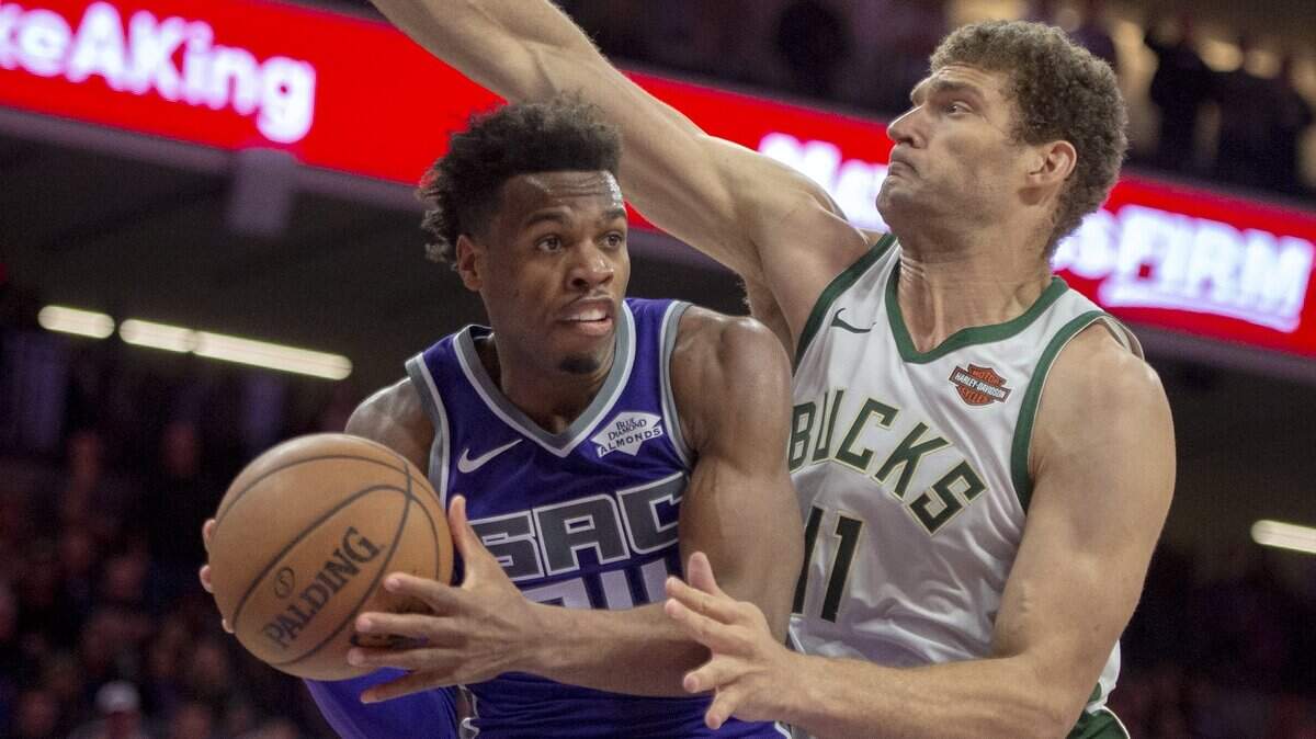 Kings guard Buddy Hield is fouled by Milwaukee Bucks center Brook Lopez on Wednesday at Golden 1 Center.