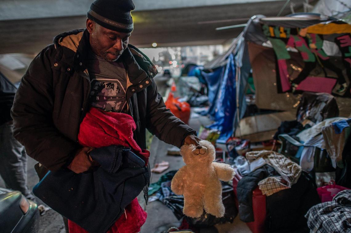 Harold Carter sorts through his partner Karen Hunter’s things, including a teddy bear she kept, at a homeless encampment on 26th Street under the W-X freeway in Sacramento on Friday, Jan. 29, 2021. Hunter died on Tuesday night during a severe storm. He thinks if there had been a warming center open that night, she definitely would have gone. “She had health conditions. She had seizures and was a diabetic,” he said. She had only been homeless less than a year he said.