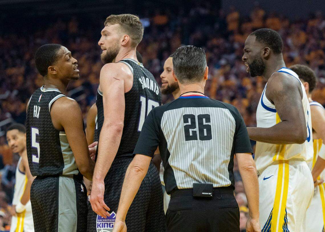 Sacramento Kings guard De’Aaron Fox (5) and Golden State Warriors forward Draymond Green (23) exchange words during Game 4 of the first-round NBA playoff series at Chase Center in San Francisco on Sunday.
