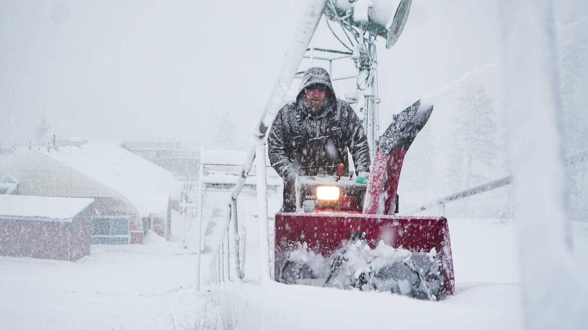 A Sierra-at-Tahoe worker clears snow with a snowblower during heavy snowfall at the base area on Tuesday, Dec. 24, 2025.