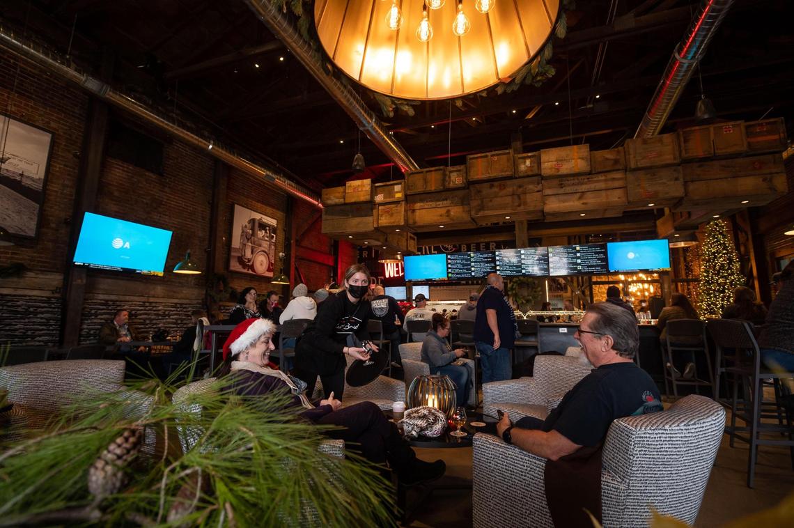 Courtnay Gregerson, center, a server at Dust Bowl Brewing Co.’s Old Town Tap House, takes an order from Ranell Burch, left, and her husband, David Burch, on the establishment’s opening day Saturday, Dec. 18, 2021, in Elk Grove. “We’re really excited to have this close by,” Ranell said, “we’ll be walking over.”