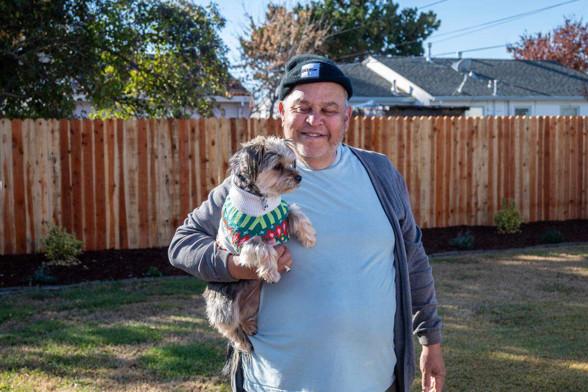 Vietnam veteran Rick Sanchez holds his dog Joey in their backyard in south Sacramento earlier this month. Habitat for Humanity helped him with fencing, landscaping, a new overhang and painted his home. The organization is asking Book of Dreams readers to support its program that helps needy veterans with home upgrades and repairs.