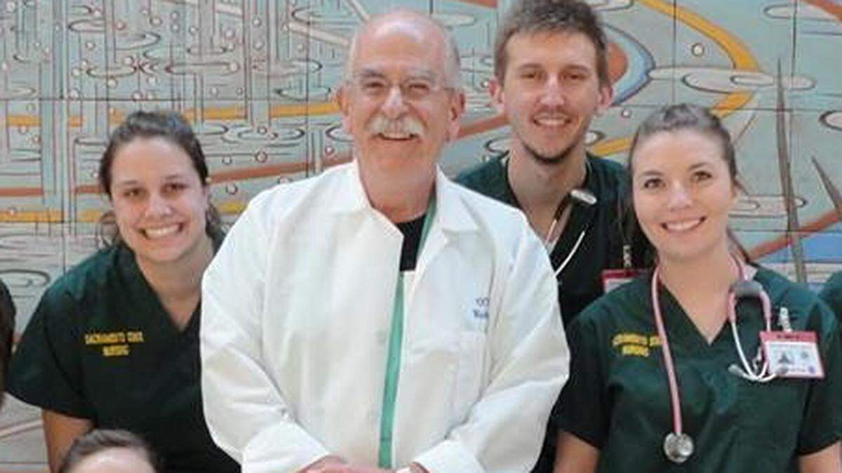Clay Abajian poses with Sacramento State students.