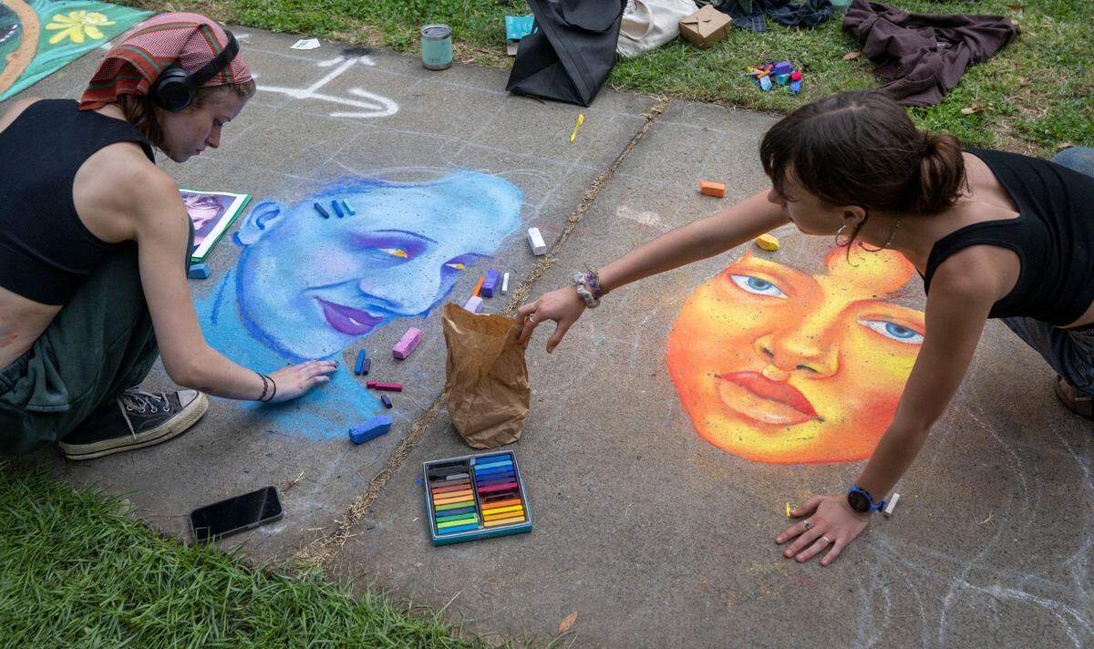 McClatchy High students Greta Huff, 17, left and Colette Combrink 17, work on their collaborative art piece during the first day of the Chalk It Up festival on Saturday, Sept. 2, 2023, at Fremont Park.