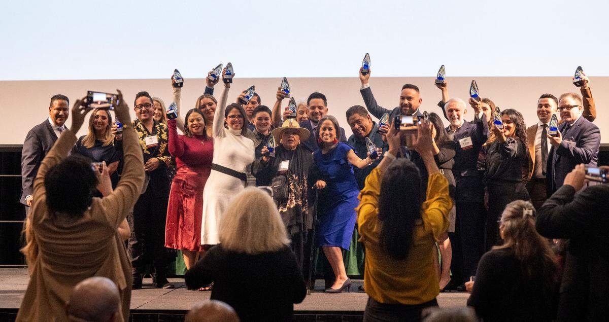 The 20 Top Latino Change Makers pose for photos holding their awards at an event at Sacramento State on Friday night.