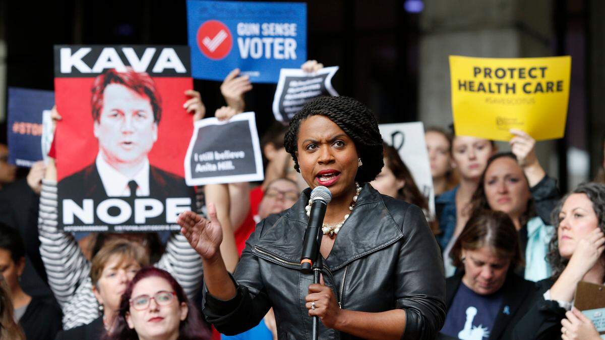 Ayanna Pressley, a Democrat running in Massachusetts’ 7th congressional district, speaks Monday at a rally at Boston City Hall ahead of an appearance by Sen. Jeff Flake, R-Ariz., who forced a follow-up FBI investigation of Supreme Court nominee Brett Kavanaugh.