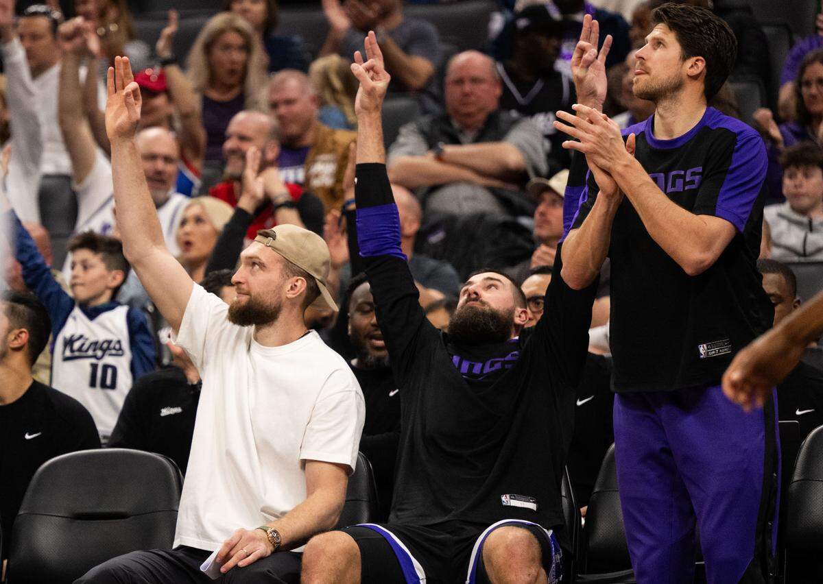 Injured Sacramento Kings center Domantas Sabonis (11) and teammate Jonas Valanciunas (17) celebrate a three-point basket against the Milwaukee Bucks on Saturday at Golden 1 Center.
