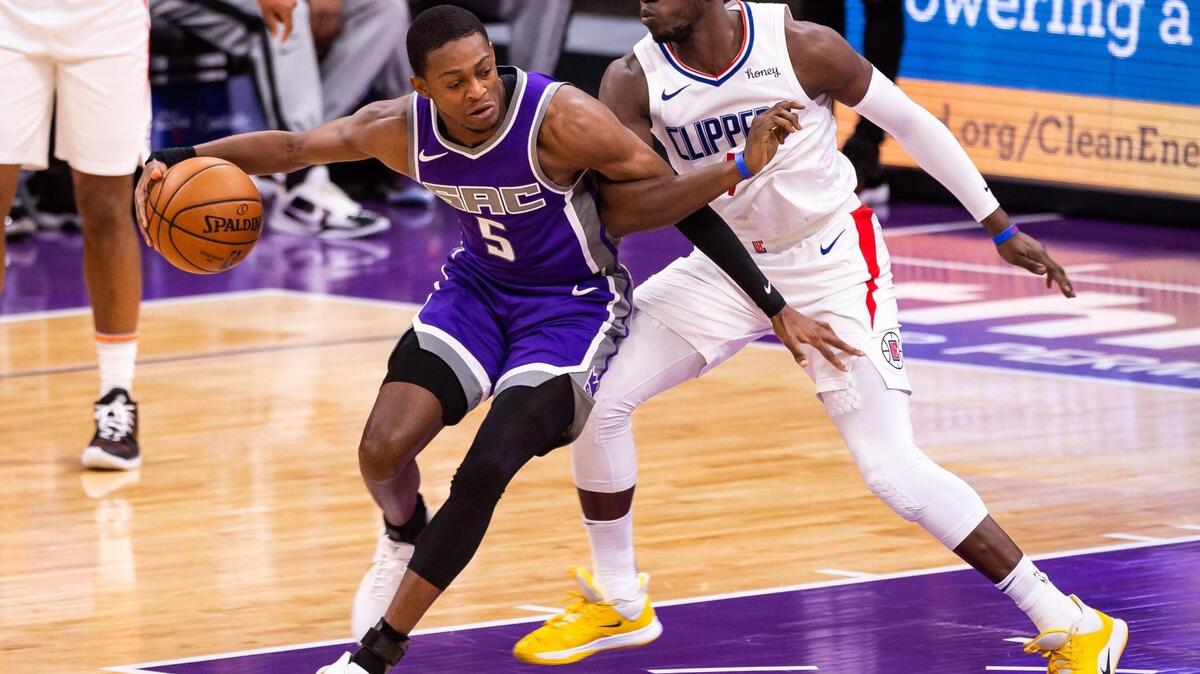 Sacramento Kings guard De’Aaron Fox (5), left, tries to fend off getting tangled by LA Clippers guard Reggie Jackson (1) during the second period of the NBA game Friday, Jan. 15, 2021, at Golden 1 Center in Sacramento.