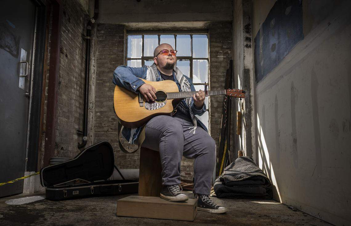 Singer-songwriter K.C. Shane, who has performed protest songs at local rallies and demonstrations, warms up his guitar to play an original song called “Someday” in Sacramento on Friday. 