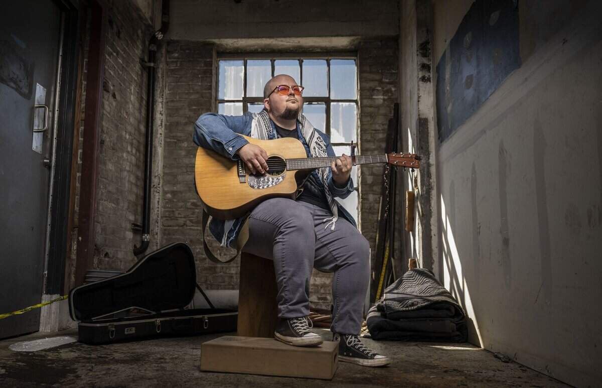 Singer-songwriter K.C. Shane, who has performed protest songs at local rallies and demonstrations, warms up his guitar to play an original song called “Someday” in Sacramento on Friday.