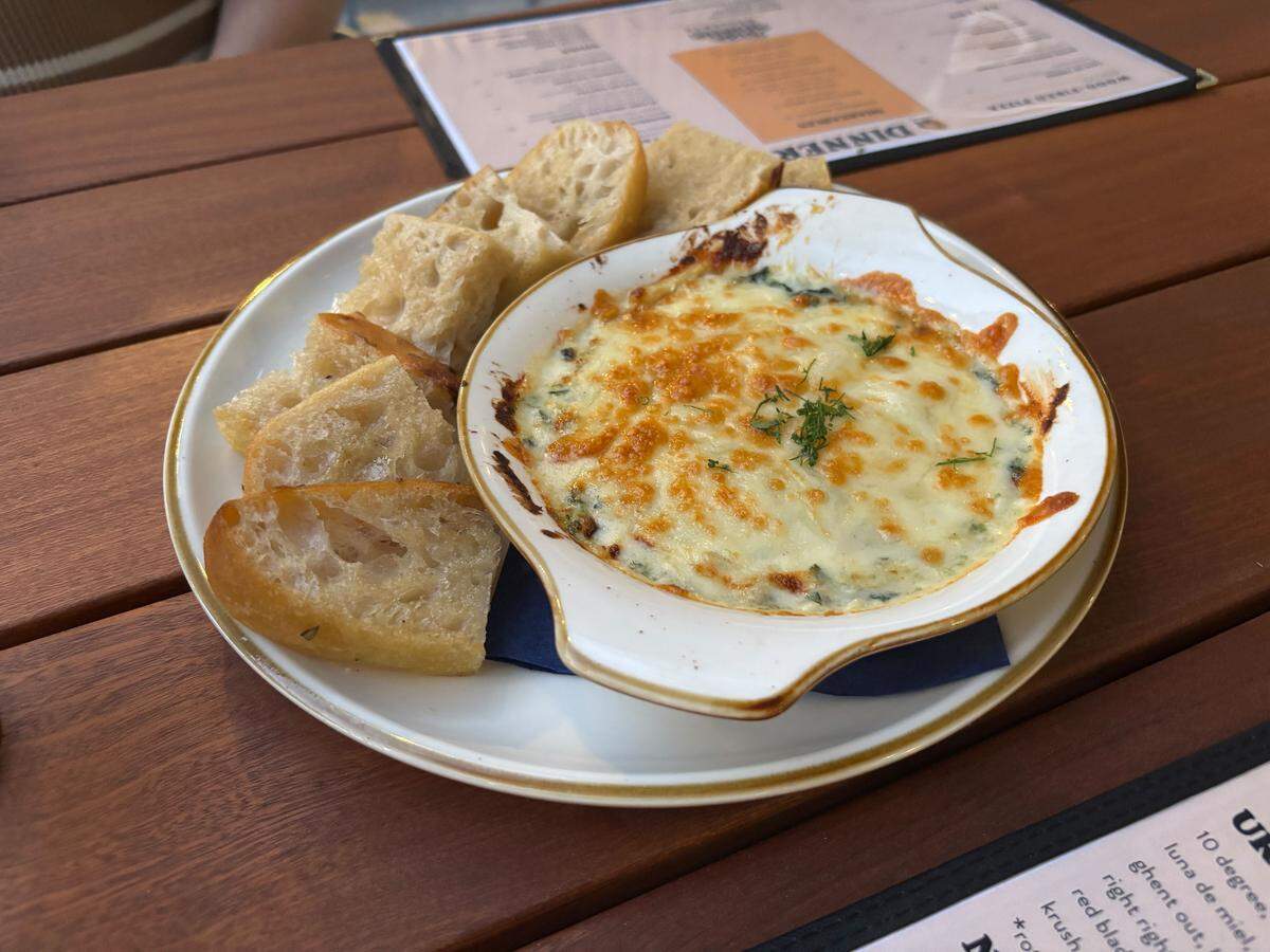 Good Neighbor’s spinach and artichoke dip comes with a warm bowl of melted cheese-topped dip alongside buttery, sturdy focaccia bread slices.
