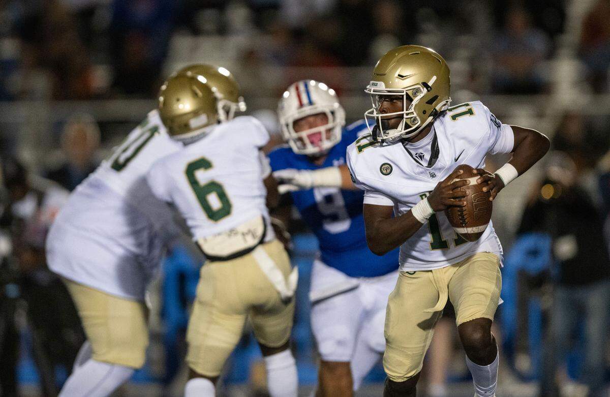 Long Beach Poly quarterback William “Deuce” Jefferson (11) looks to pass against the Folsom Bulldogs on Friday, Aug. 23, 2024, in Folsom.