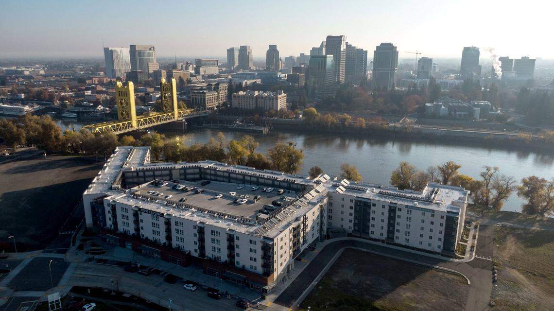 The Tower Bridge and Sacramento skyline stand behind the recently opened 805 Riverfront apartments in West Sacramento on Dec. 6, 2024. 