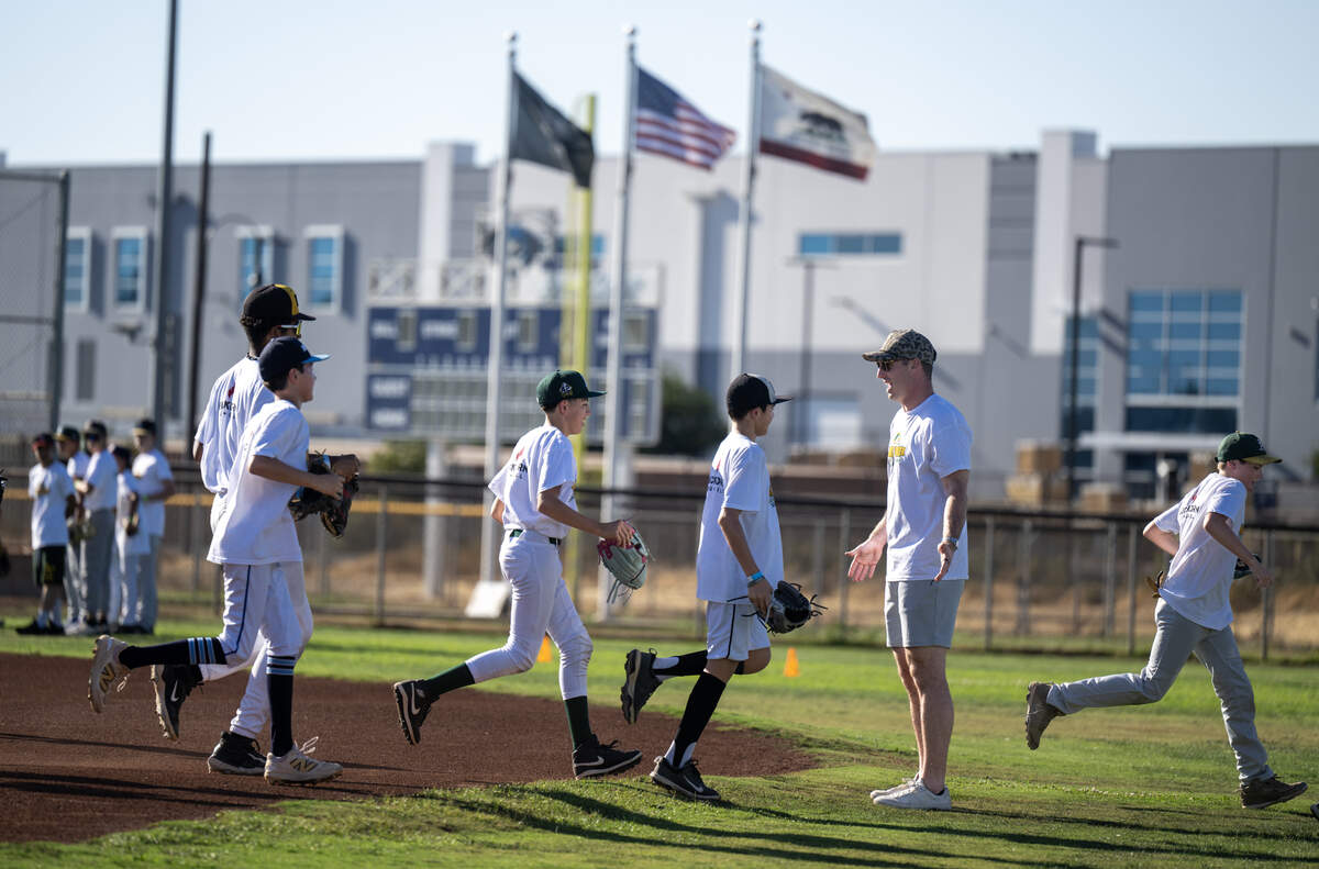 Athletics player Brent Rooker greets players as they jog to their next station during his youth sports camp in Sacramento on Thursday at Army Depot Park.