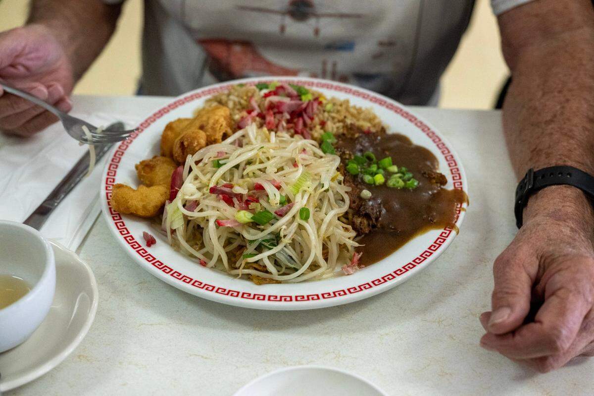 First-time customer Dick Williams orders the combination plate with chow men, shrimp, fried rice and egg foo young with gravy at the Chicago Cafe in Woodland last month.