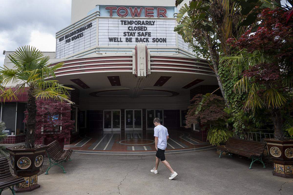 A pedestrian walks by the Tower movie theater closed to the public during the coronavirus outbreak on Tuesday, March 24, 2020 in Sacramento.