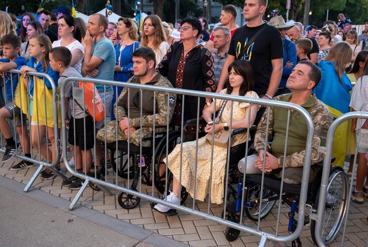 Ukrainian soldiers Vadym Fedorov, left, and Oleg Dubovyi, right, sit in wheelchairs as the Ukrainian American House hosts an event at the state Capitol on Friday to honor Ukraine’s Independence Day. Fedorov and Dubovyi came to the U.S. to receive prosthetic surgery after being injured in their country’s war with Russia.