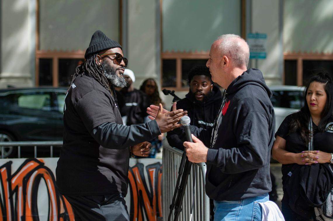 Community activist Berry Accius, left, founder of Sacramento’s Voice of the Youth program, shakes hands with Mayor Darrell Steinberg as he brings him up to speak to the crowd gathered during the march for Communities Against Gun Violence at Ali Youssefi Square on Sunday in downtown Sacramento.