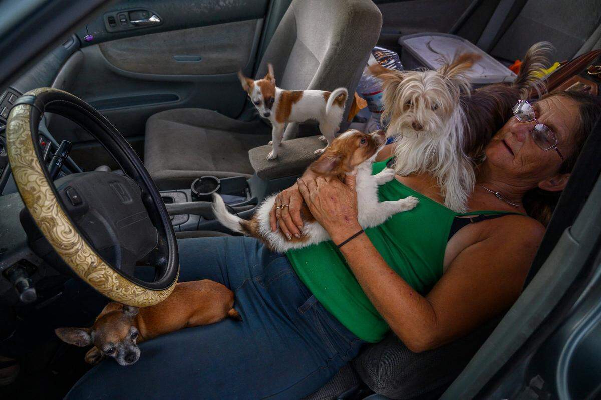 Gwen Mayse leans back in her seat with her and her daughter’s dogs while camping along Railroad Drive in Sacramento in 2019. At the time, she was having a hard time finding an apartment or shelter to take them with their pets.