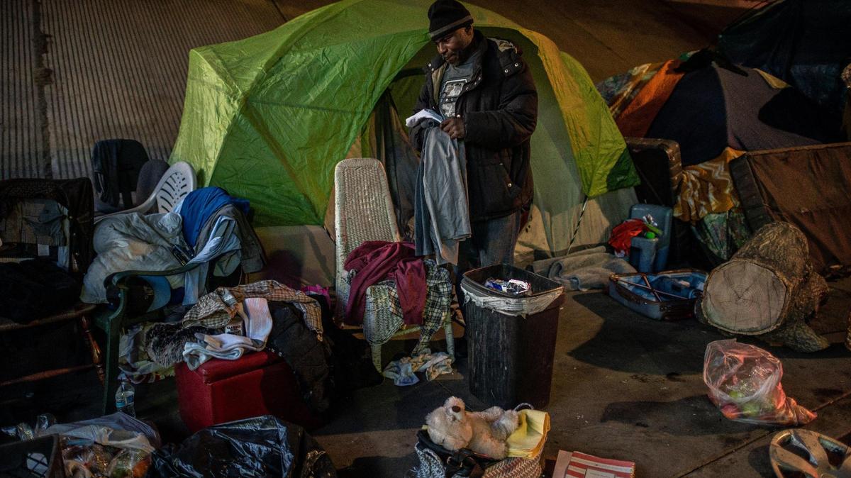 Harold Carter, 52, sorts through the tent that belonged to his partner of 27 years, Karen Hunter, 57, in January. Hunter died during a severe storm at a homeless encampment on 26th Street under the W-X freeway in Sacramento. Sacramento might convert the nearby YMCA into housing for the homeless, a new YMCA facility and childcare/