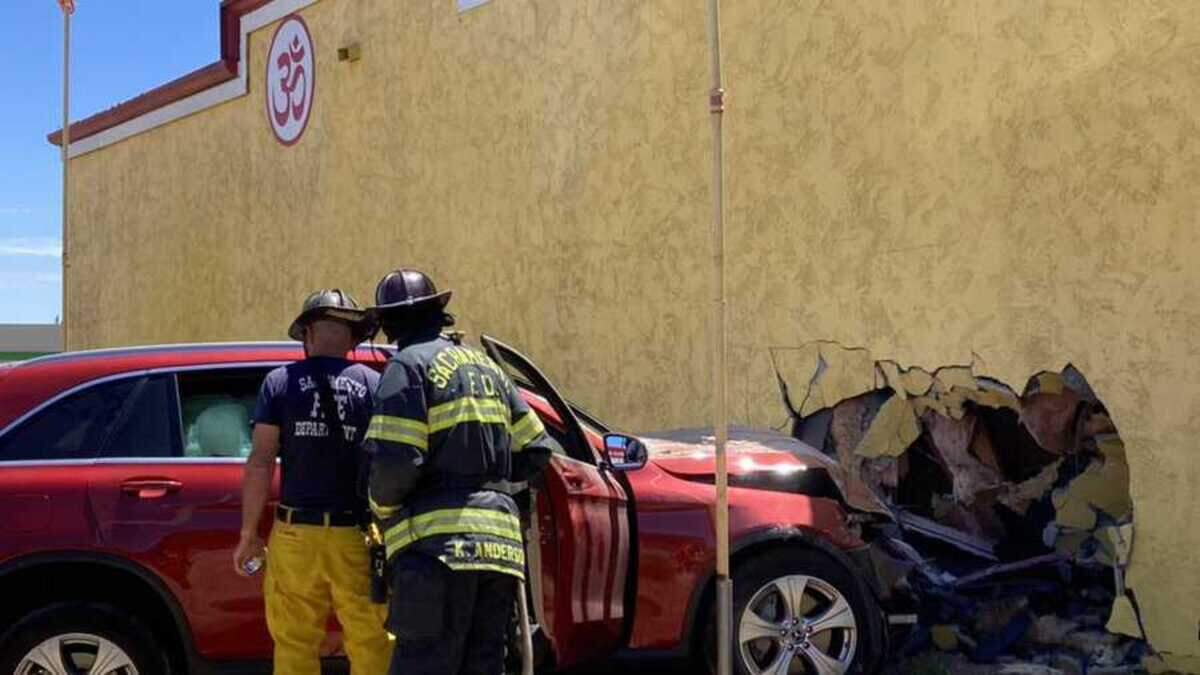 Sacramento Fire Department firefighters inspect a car that crashed into the Sacramento Hindu Temple on Saturday morning, July 2, 2022. A man was arrested on suspicion of hit and run.
