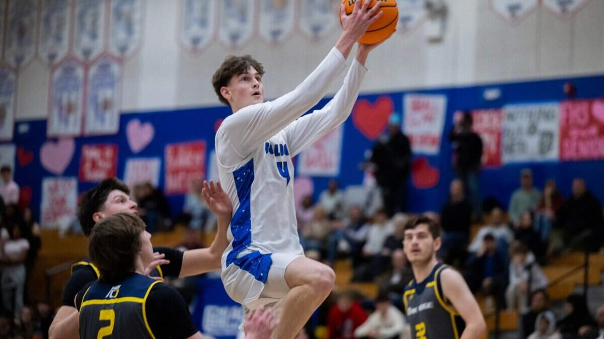The Folsom Bulldogs’ Chase Rawlins (4) makes a layup past the Oak Ridge Trojans’ Connor Sullivan (2) on Friday. The Bulldogs have the No. 3 seed in Division I.