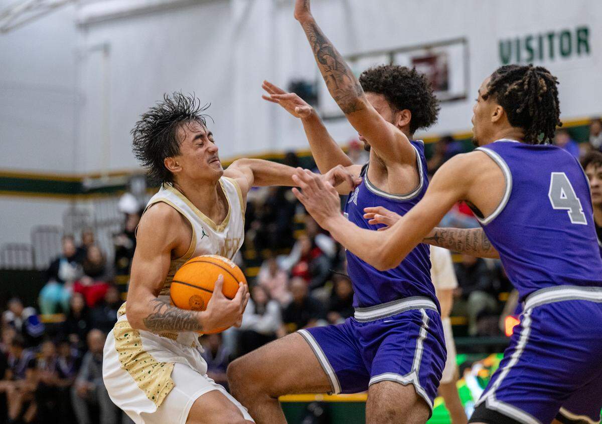 The Rio Americano Raiders’ Adrian Devenecia (4) pushes the Sacramento Dragons’ Sir Marius Jones (2) as he defends the play in the second half of a CIF Sac-Joaquin Section boys basketball playoff game Wednesday in Sacramento.