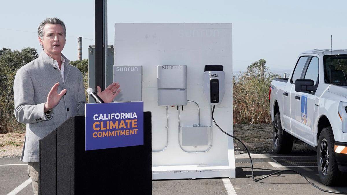 With a solar panels above him and a charging station display in the background, Gov. Gavin Newsom discusses climate legislation he is about to sign at Mare Island in Vallejo on Friday, Sept. 16, 2022. Newsom signed a package of legislation that accelerates the climate goals of the nation’s most populous state.