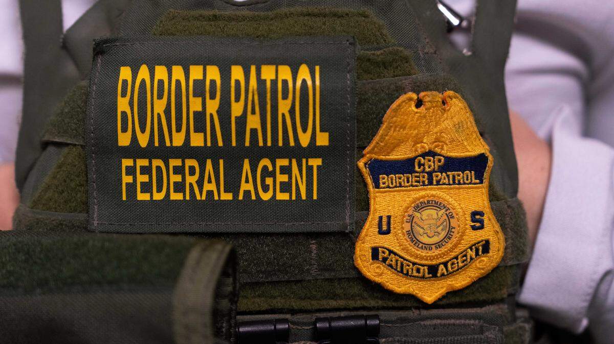 A U.S. Customs and Border Protection agent stands outside immigration court in New York in June. Border Patrol agents announced Friday that 87 commercial drivers were arrested in two recent immigration enforcement operations in Southern California.
