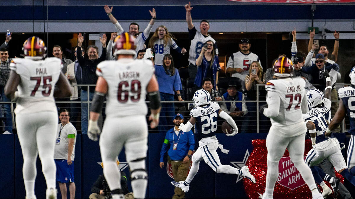 Washington Commanders guard Chris Paul (75) and center Tyler Larsen (69) and offensive tackle Charles Leno Jr. (72) look on as Dallas Cowboys cornerback DaRon Bland (26) returns an interception for a touchdown during the second half Thursday, Nov. 23, 2023, at AT&T Stadium in Arlington, Texas.