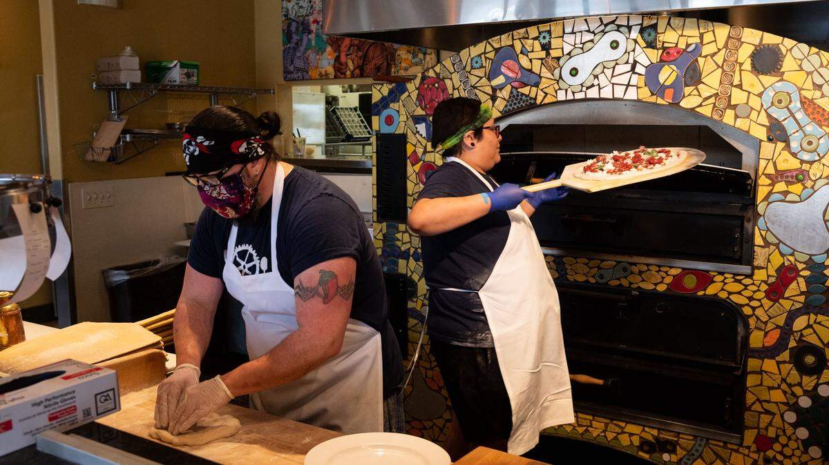 OneSpeed’s Beau Chandler, left, kneads pizza dough as Shannon Jessepe inserts a pizza into the oven Wednesday, April 8, 2020, in East Sacramento. The restaurant is seeking a new location as its lease will not be renewed. 