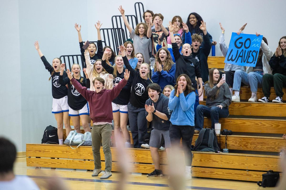 The Waldorf Waves’ crowd cheers after Elijah Neuhaus (22) makes a 3-pointer during the first half at a home game against John Adams Academy on Dec. 12.
