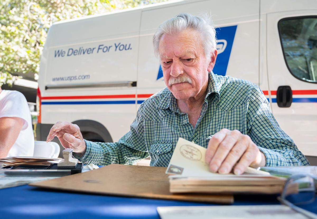 Ernie Teays puts a “Commerative Re-Run” stamp on mail carried during the Pony Express Annual Re-Ride near the Pony Express Statue in Old Sacramento on June 27, 2024.