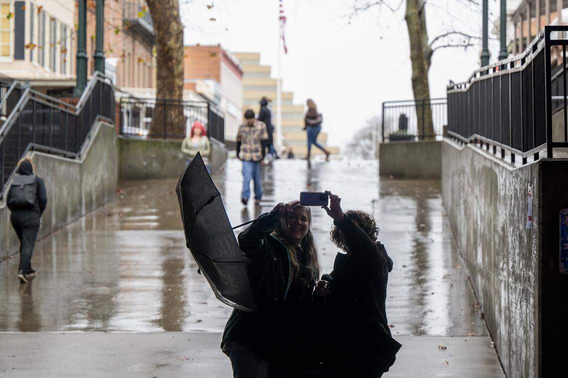 Visitors to Old Sacramento take selfies as they duck out of the rain on Monday, Feb. 16.