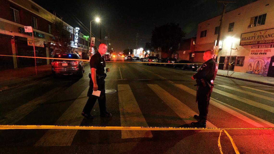 Police officers stand guard after illegal fireworks seized at a South Los Angeles home exploded, in South Los Angeles Wednesday evening, June 30, 2021. A cache of the illegal fireworks exploded, damaging nearby homes and cars and causing injuries, authorities said. (AP Photo/Ringo H.W. Chiu)