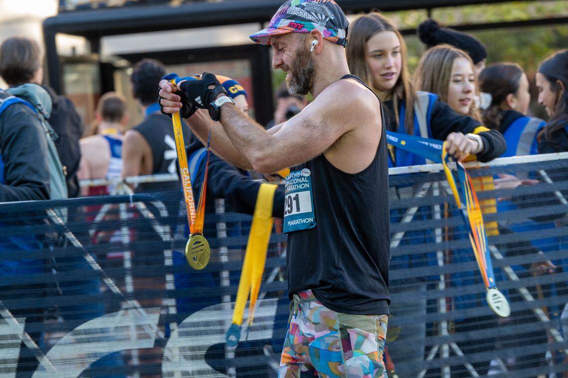 Zee Jenkins of San Francisco collects his medal for finishing the California International Marathon on Sunday in Sacramento.