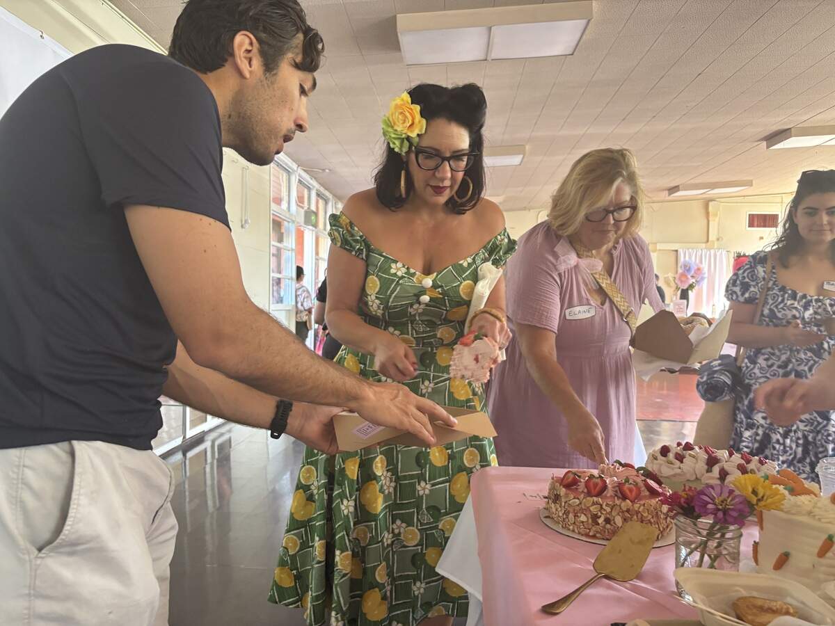 Dyana O’Brien serves a slice of her strawberry prosecco angel food cake at Sugar Social dessert picnic on Saturday morning at E. Claire Raley Studios for the Performing Arts.