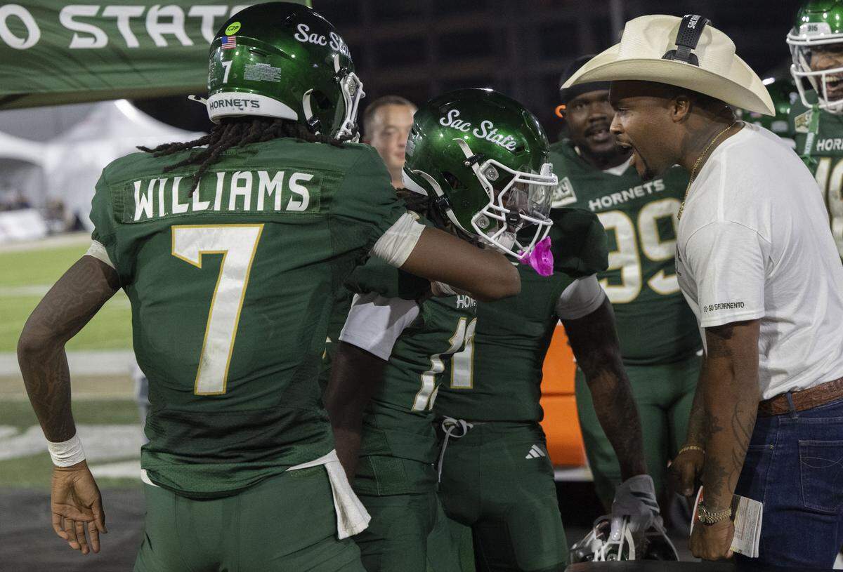 Sacramento State Hornets quarterback Cardell Williams (7) and head coach Brennan Marion celebrate a touchdown by wide receiver Ernest Campbell (13) during an NCAA football game against the Mercyhurst Lakers on Saturday at Hornet Stadium.