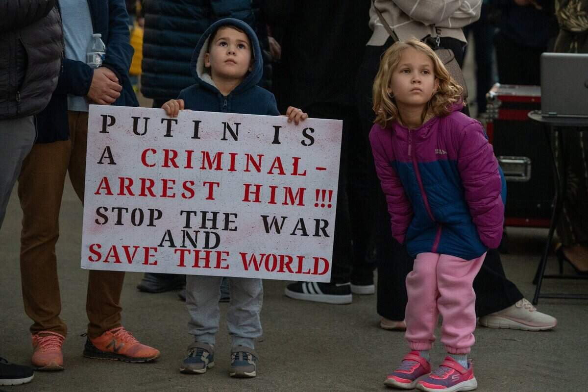 Alex Amendt, 4, of Carmichael, holds a sign calling for the arrest of Russian President Vladimir Putin as he attends an event at the state Capitol on Monday, Feb. 24, 2025, marking the third anniversary of Russia’s invasion. He and his sister eigh-year-old sister Katya Amendt, right, came with their family from Russia two years ago.