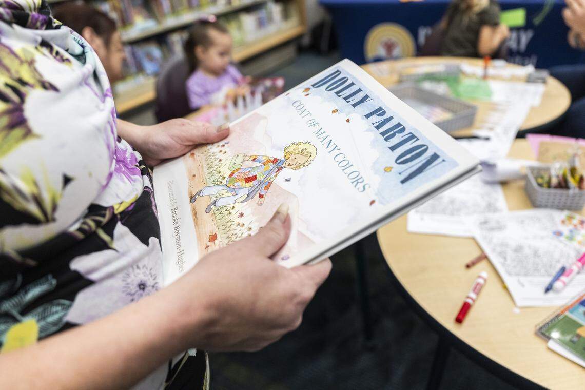 Danielle Whittenburg, of Woodland, holds a book by Dolly Parton that was given to her granddaughter as they attend the launch of the Dolly Parton Imagination Library program at the Sacramento Library on Wednesday. Sacramento County children under age 5 can receive a monthly free book in the mail through the program.