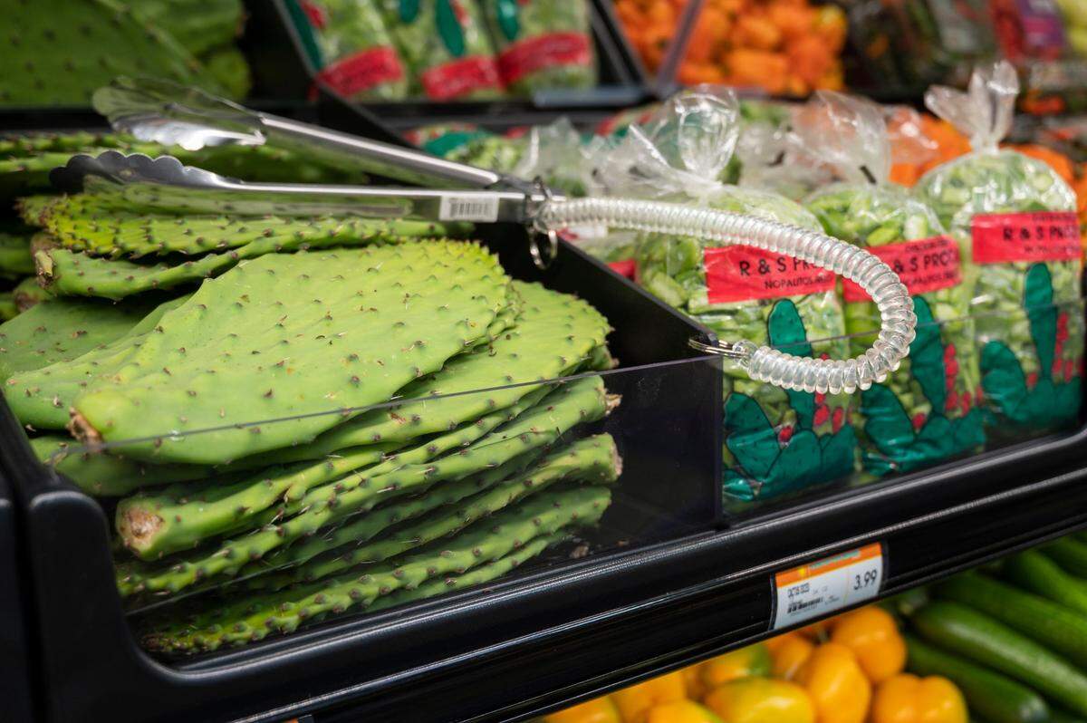 Fresh cactus leaves are displayed in the produce section.