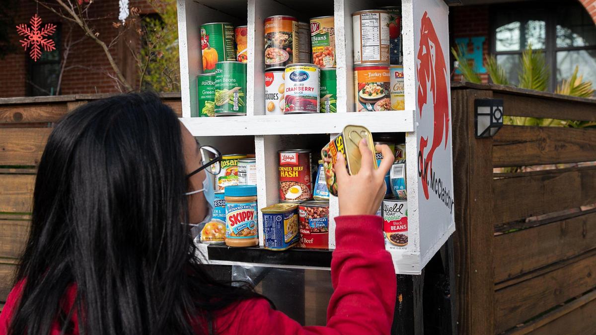McClatchy High senior Ashley Jun restocks a little food pantry on H Street on Thursday, Jan. 14, 2021, in East Sacramento. Jun built four little food pantries to help those in need. A recent report by the California Budget and Policy Center found that six in 10 Californians with incomes below $35,000 struggle to pay for food and other necessities.